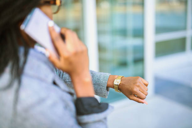 empresaria africana comprobación de tiempo. - gold watch fotografías e imágenes de stock