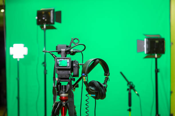 istock The camera on the tripod, led floodlight, headphones and a directional microphone on a green background. The chroma key. Green screen 897584090