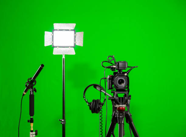 istock The camera on the tripod, led floodlight, headphones and a directional microphone on a green background. The chroma key. Green screen 897584094