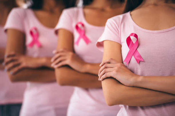 Breast cancer awareness. Cropped image of group of young multiracial woman with pink ribbons are struggling against breast cancer. Breast cancer awareness concept. breast stock pictures, royalty-free photos & images