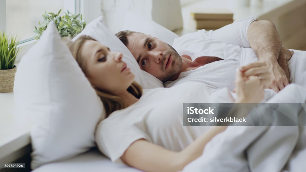 Nahaufnahme eines Paares mit Beziehungsproblemen emotionalen Gespräch beim liegen im Bett zu Hause - Lizenzfrei Paar - Partnerschaft Stock-Foto