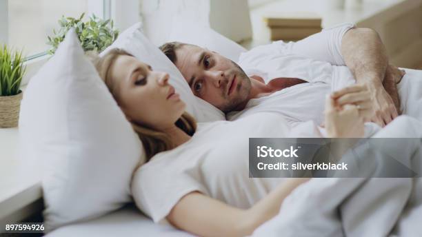 Closeup Of Couple With Relationship Problems Having Emotional Conversation While Lying In Bed At Home Stock Photo - Download Image Now