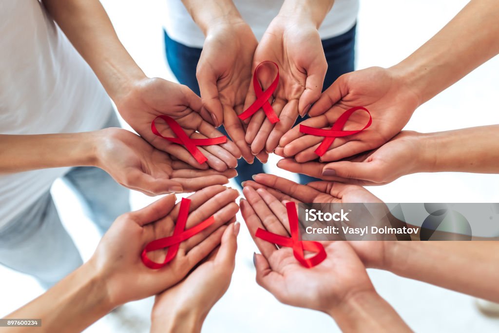 AIDS awareness concept. Group of young multiracial woman with red ribbons in hands are struggling against HIV/AIDS. AIDS awareness concept. AIDS Stock Photo