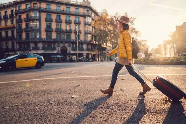 Tourist visiting Barcelona Young woman with suitcase walking at the street in Barcelona fall travel stock pictures, royalty-free photos & images