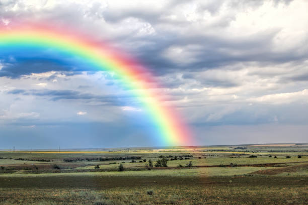 Rays of the sun breaking through the stormy sky, forming a marvelous rainbow