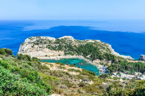 Beachgoers enjoy famous Anthony Quinn Bay beach in Rhodes, Greece