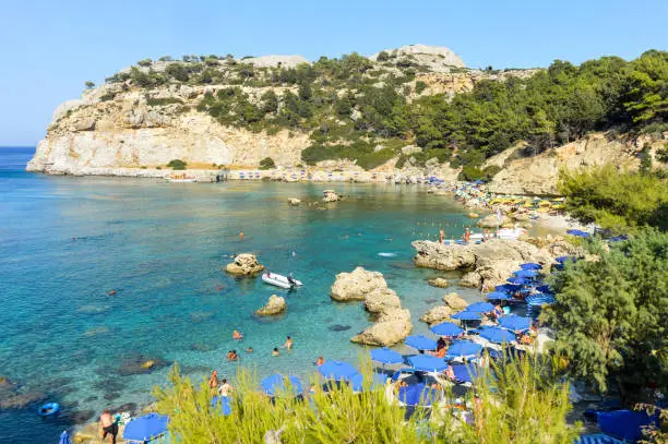 Beachgoers enjoy famous Anthony Quinn Bay beach in Rhodes, Greece