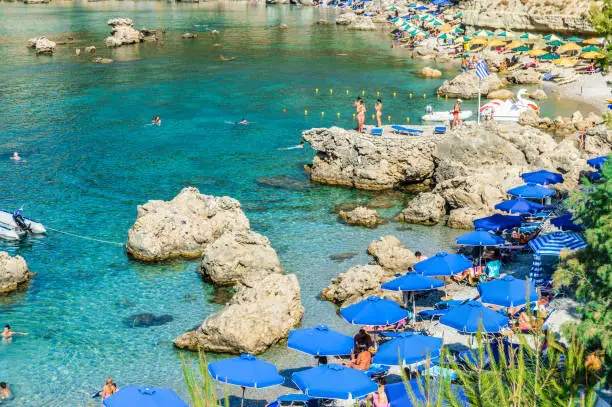 Beachgoers enjoy famous Anthony Quinn Bay beach in Rhodes, Greece