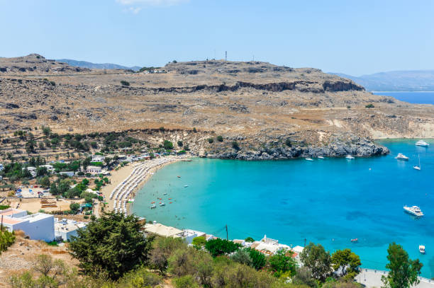 istock Beachgoers enjoy beautiful Lindos Beach in Rhodes, Greece 897646908