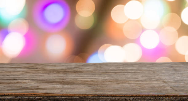 istock Rrustic wood table in front of glitter and bright bokeh lights 897647352