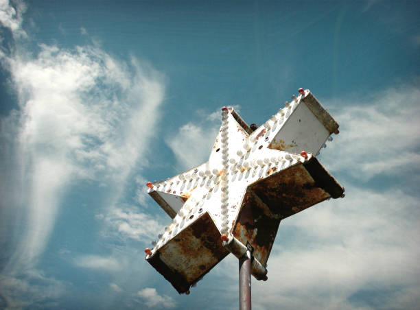 Old arrow shaped sign pointing way to hotel that no longer exists.