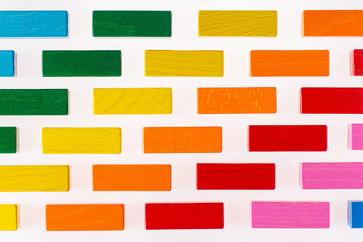 Multicolored wood background. Background with colorful shapes wooden blocks. Colorful wall, toy colored wooden bricks. Multicolor wooden blocks.