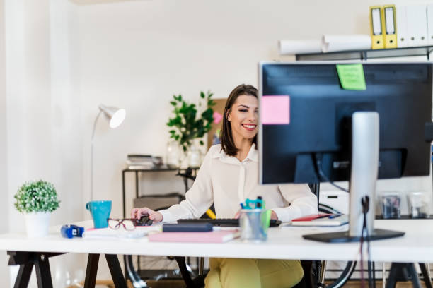 istock Young woman working in her office, typing on a desktop PC keyboard 897656484