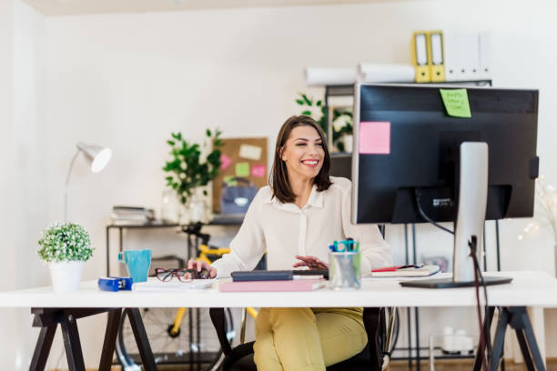 istock Young woman working in her office, typing on a desktop PC keyboard 897656552