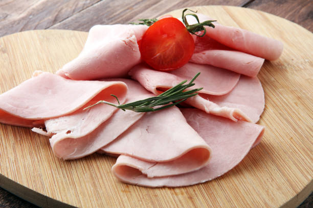 istock Sliced ham on wooden background. Fresh prosciutto. Pork ham sliced. 897662086