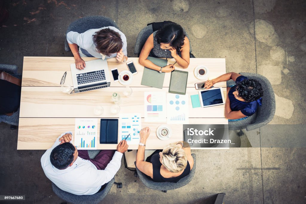 Group of financial professionals analyzing markets Group of entrepreneurs and business people sitting at the table and discussing potential cooperation and joint projects. Finance Stock Photo