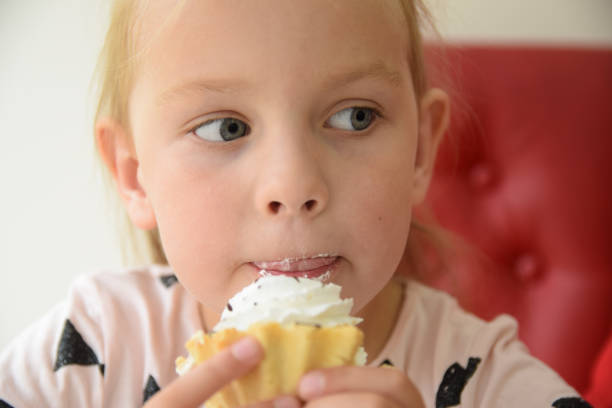 istock Girl eating a cupcake 897671610