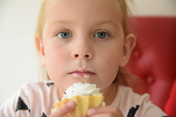istock Girl eating a cupcake 897671612