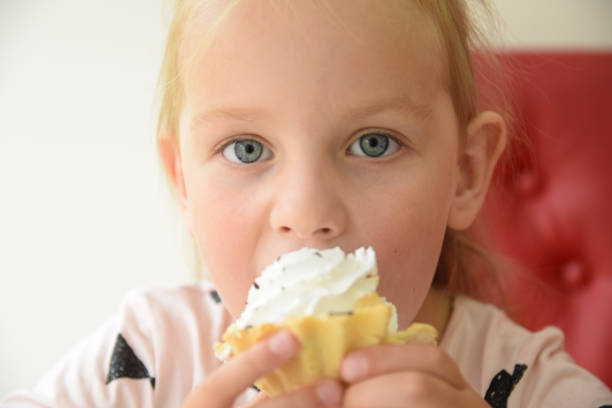 istock Girl eating a cupcake 897671620