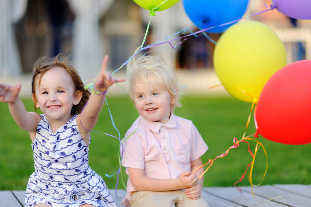 男の子と女の子を持つ楽しさし、カラフルな風船で誕生日パーティーを祝う - child balloon outdoors little boys ストックフォトと画像