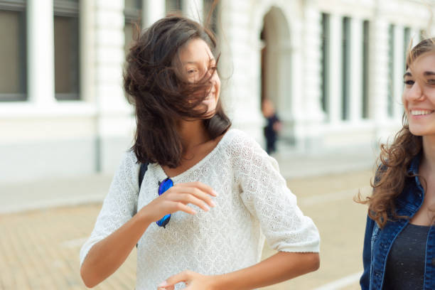 istock Two happy women walking around city 897724036