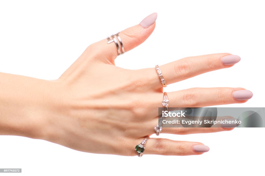 Main féminine en argent anneaux or - Photo de Ongle libre de droits
