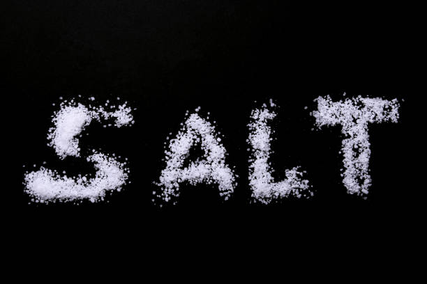 istock White sea salt isolated on a black background. Selective focus. 897765034