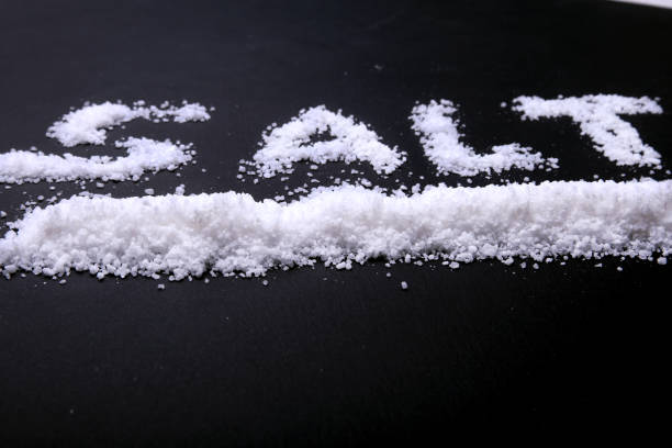 istock White sea salt isolated on a black background. Selective focus. 897765162