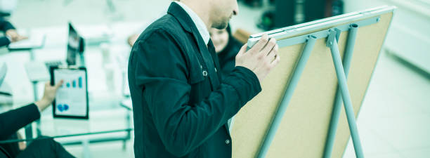 istock closeup - Manager gives a presentation of a marketing project 897765302