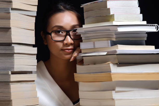 istock Girl in white shirt reading many textbooks on table with many high stacking 897791412