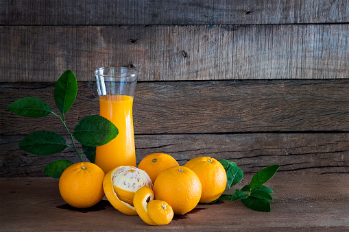 Fresh Oranges and glass of orange juice on the wooden plank / Still life image and selective focus