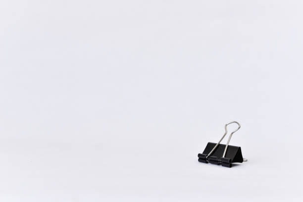 Black paper clips on white background with copy space