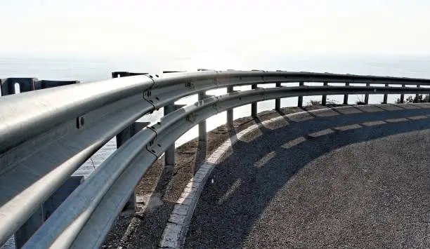 detail of metal guard rail under a cloudy sky