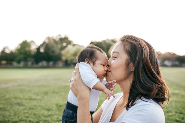 adorable bébé - baby kissing mother lifestyles photos et images de collection