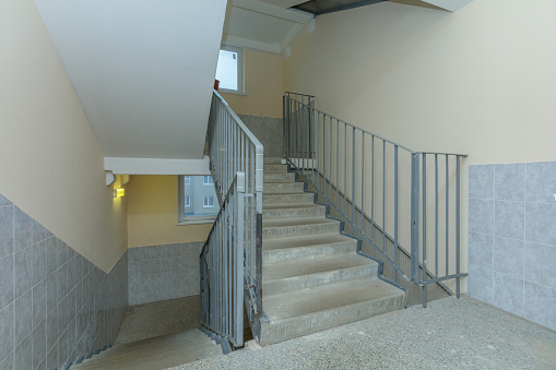 empty entrance in apartment building stairwell grey color