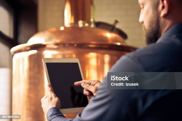 Master Brewer Using Digital Tablet At Microbrewery Stock Photo - Download Image Now - Brewery, Owner, Using Digital Tablet