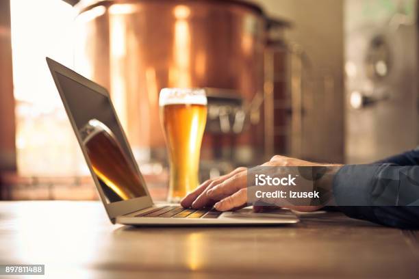Brewer Using Laptop At Micro Brewery Stock Photo - Download Image Now - Beer - Alcohol, Brewery, Computer