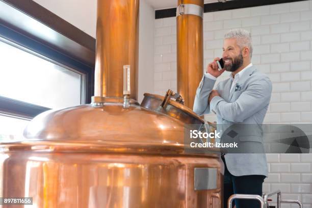 Microbrewery Owner Using A Mobile Phone Stock Photo - Download Image Now - Adult, Adults Only, Alcohol - Drink