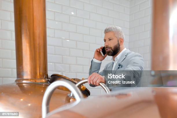 Businessman Using Mobile Phone In His Micro Brewery Stock Photo - Download Image Now