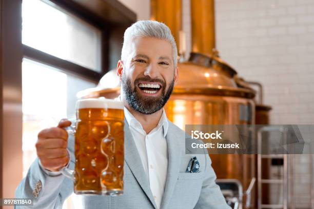 Laughing Businessman Holding A Beer Mug In Microbrewery Stock Photo - Download Image Now