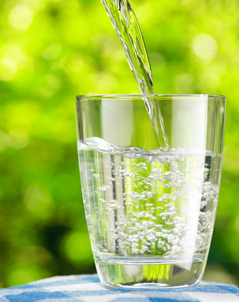 istock Glass of water on nature background 897821602