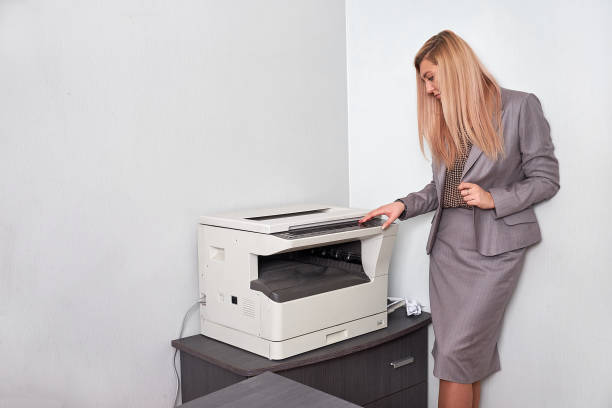 istock Businesswoman working on a copy machine at the office 897827002