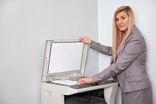 istock Businesswoman working on a copy machine at the office 897827048