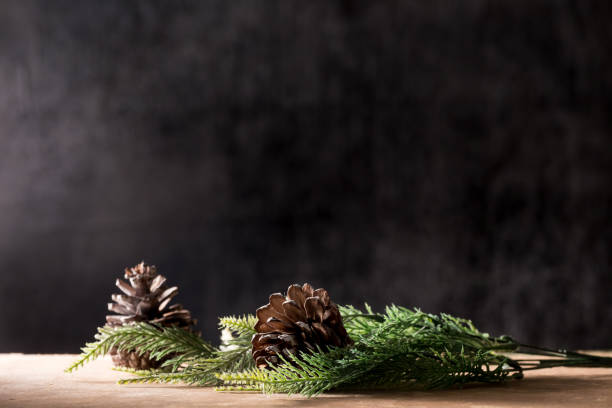 istock Pine cones with branches on the wooden table, black background, free space for text 897837306