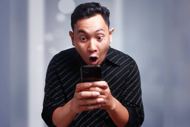 istock Young Man Texting Reading Chatting on His Phone, Surprised Happy 897839682