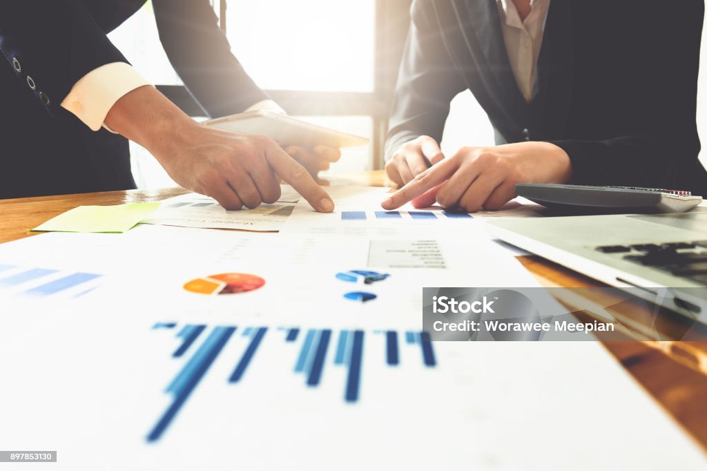 Close up of business man hand pointing at business document on financial paper on wooden desk during discussion at meeting. Group support concept. Trust Stock Photo