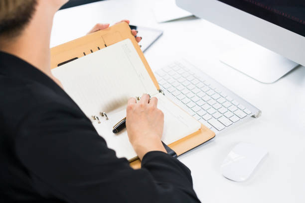 istock young woman writing in notebook by office desk 897880476