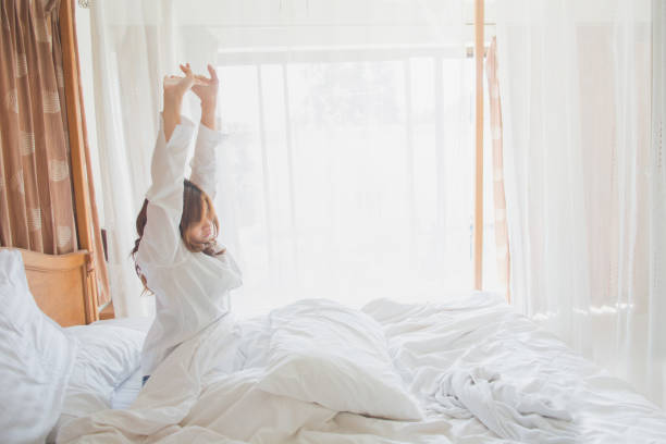 istock Beautiful woman waking up in her bed 897880482