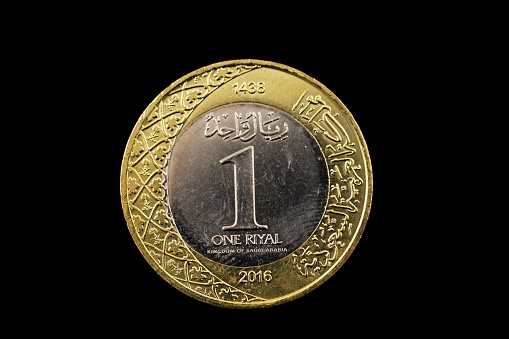 A super macro image of a one saudi riyal coin isolated on a black background
