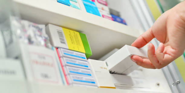 Closeup pharmacist hand holding medicine box stock photo